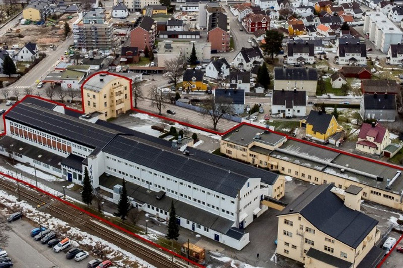 Bilde tatt ovenfra som viser flere industribygg og et jernbanespor