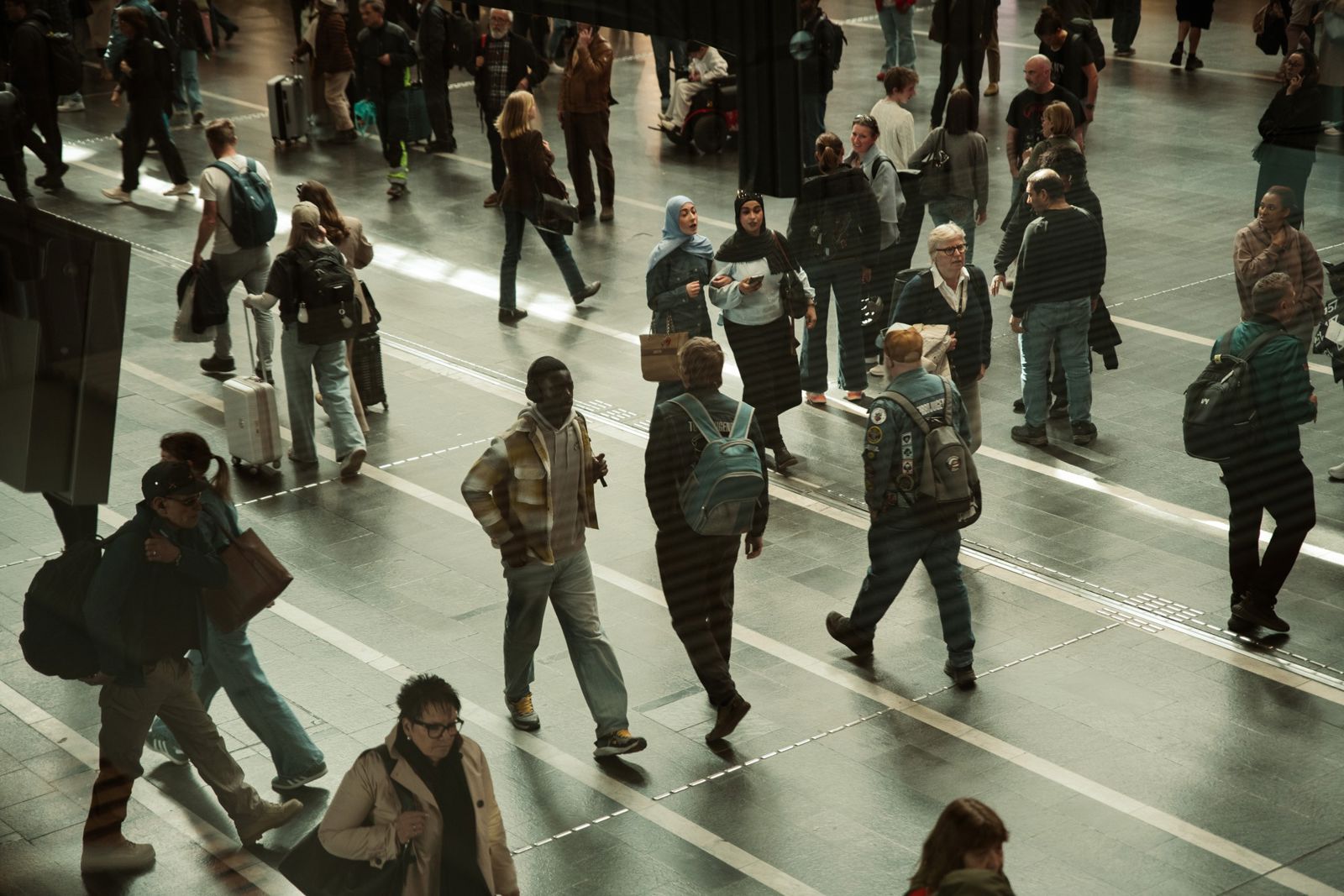 Stort åpent areal, trapper og rulletrapper opp til sentralhallen, butikker på begge sider.