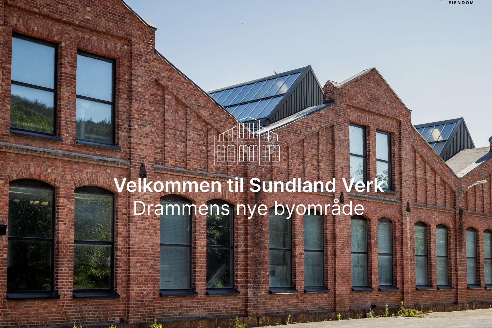 Fasaden på et av byggene på Sundland. Byggene er bygget i rustrød teglstein og har store vinduer.