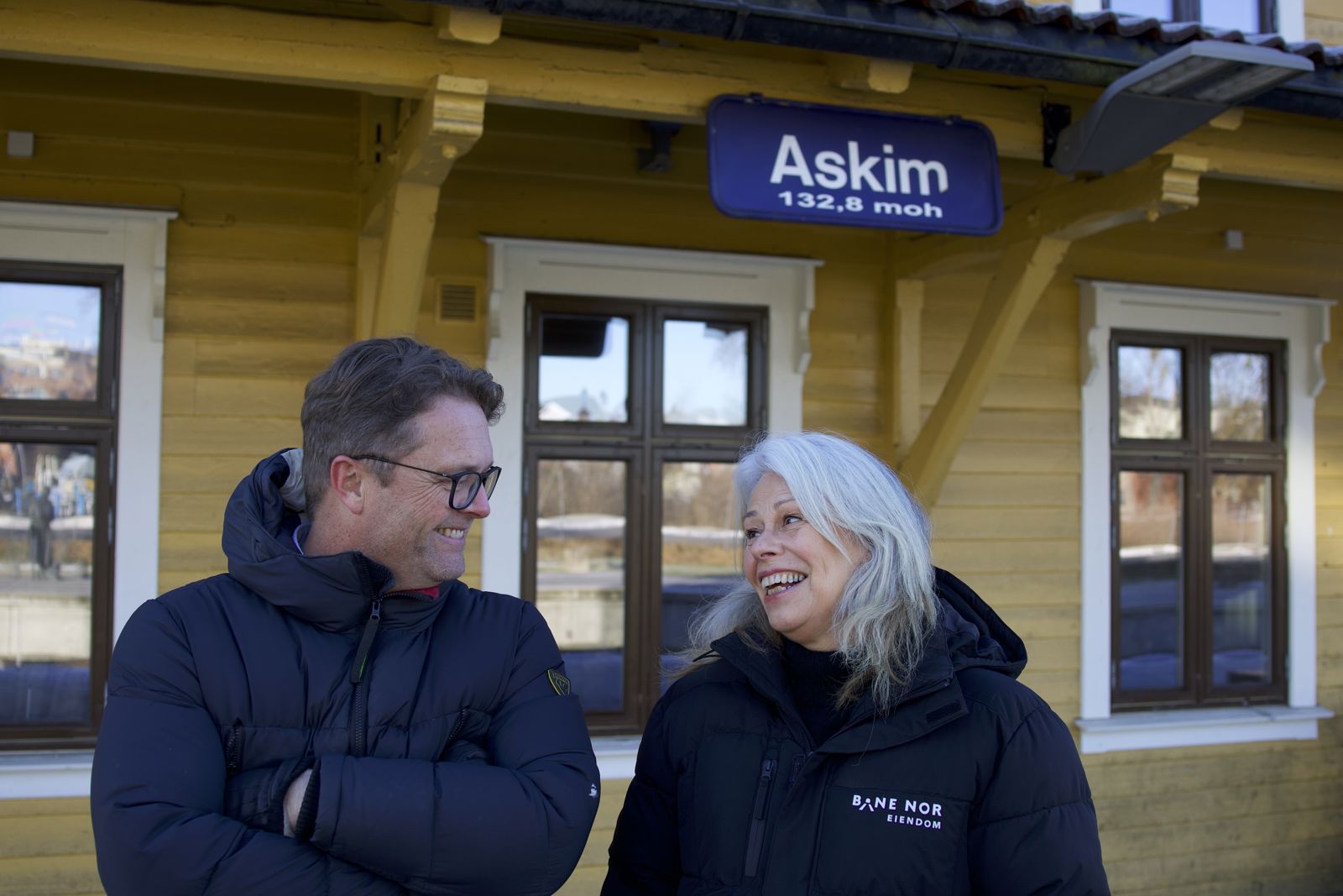 Mann og dame foran Askim stasjon, smiler.