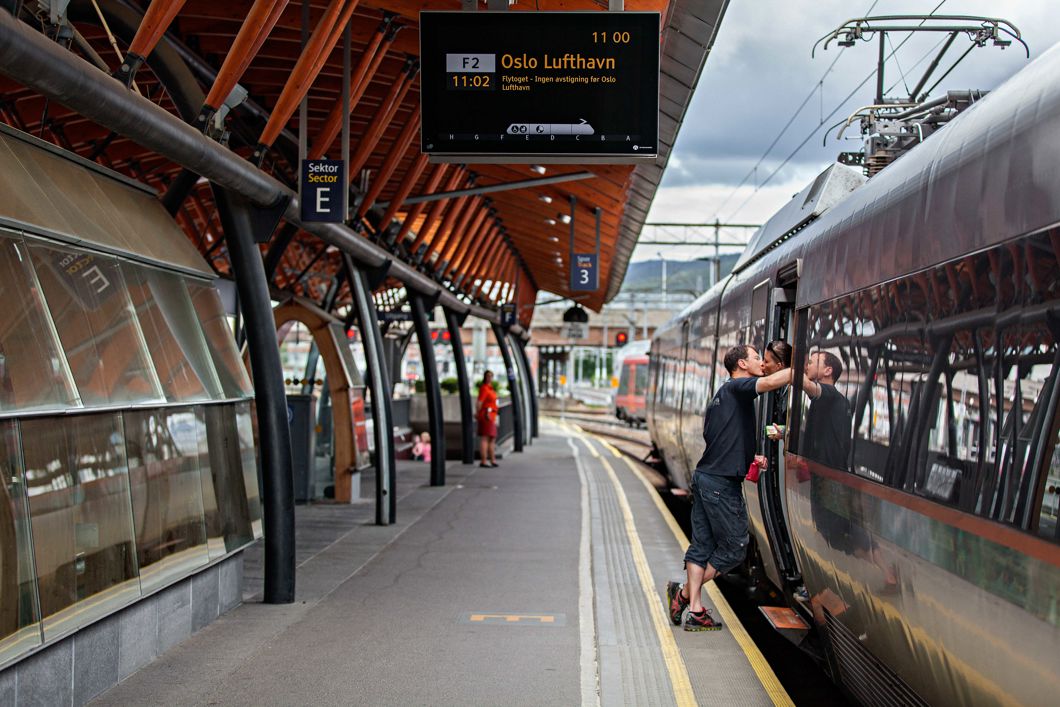 et par kysser hverandre i føråpningen på et tog som står på perrongen