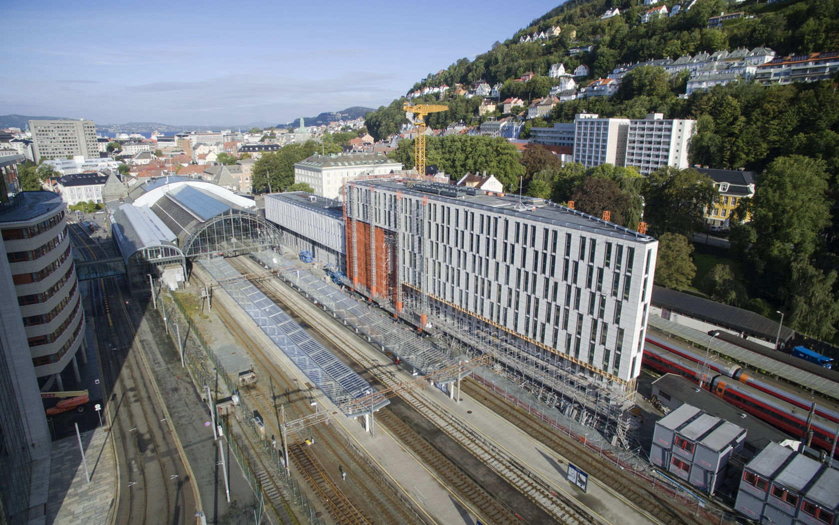 høyt og smalt lyst kontorbygg langs perrongen på stasjonen