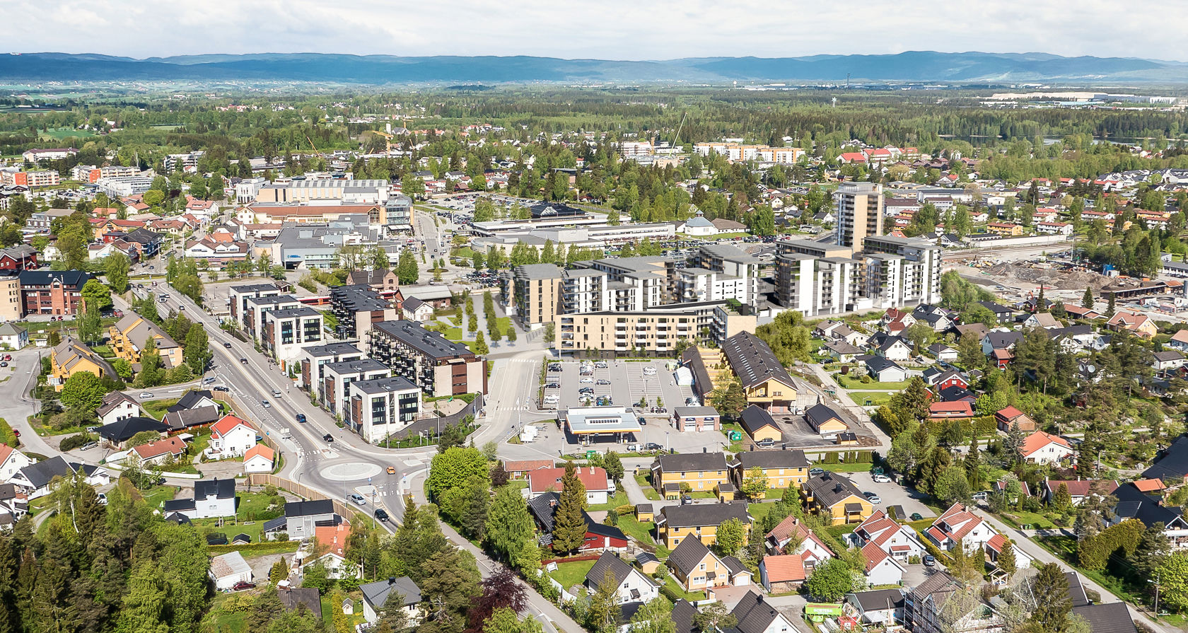 dronebilde over tettbebygd strøk med illustrasjonre av nye bygg